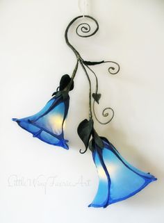 two blue glass flowers hanging from a hook