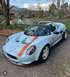 a blue and orange sports car parked in a driveway