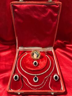 an open red case with jewelry inside on a red cloth covered tableclothed surface