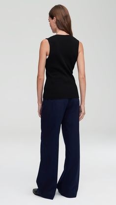 Elevate your workwear with a classic knit rib waistcoat. Designed to be worn as a top on its own or styled over a shirt or blouse, our waistcoat reimagines traditional suiting for the modern working woman. The slim silhouette features an all over ribbed pattern, a fitted v-neck silhouette, and button closure. Wear with relaxed trousers and sneakers for a cozy yet put-together ensemble. Versatile Fitted Sweater Vest For Work, Fitted Versatile Sweater Vest For Workwear, Classic Cotton Sweater Vest For Work, Versatile Cotton Workwear Vest, Versatile Cotton Vest For Work, Versatile Cotton Knit Top For Work, Chic Cotton Sweater Vest For Work, Stretch Knit Top For Work, Chic Black Sweater Vest For Work