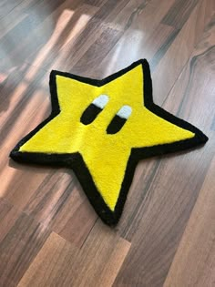 a yellow and black star shaped rug sitting on top of a wooden floor