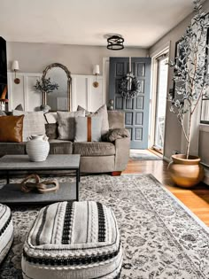 a living room filled with furniture and a large rug on top of a hard wood floor