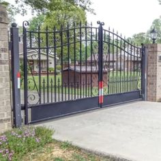 an iron gate in front of a brick house