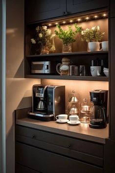 a coffee maker and some cups on a counter in front of a shelf with lights