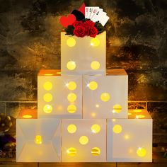 a lighted box with roses and cards on top is sitting in front of a wall