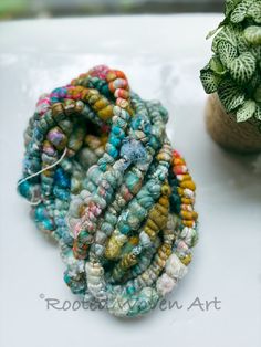 several bracelets sitting on top of a table next to a potted plant