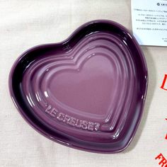 a purple heart shaped dish sitting on top of a table