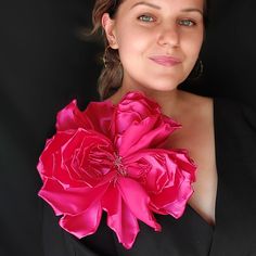 a woman in a black dress holding a pink flower