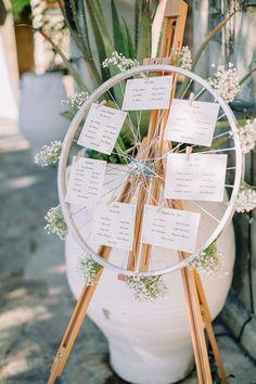 a white vase filled with lots of flowers next to a ferris wheel on top of a sidewalk