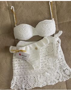 a white crochet bra and panties on a bed