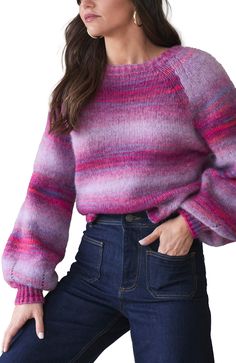 a woman wearing a pink and purple sweater