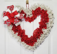 a heart shaped wreath hanging on the front door