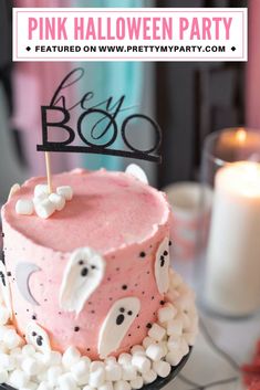 a pink cake with white marshmallows on it and a black sign that says boo