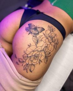 a woman's thigh with flowers and a butterfly on it