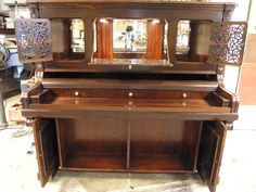 an antique piano is being displayed in a shop