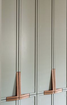 two wooden pegs are attached to the side of some cupboards in a kitchen