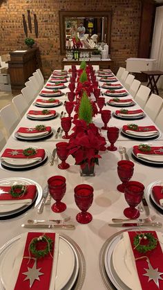 the table is set with red and white place settings