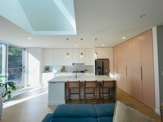 an open kitchen and living room area with couches in front of the counter top