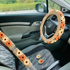 the interior of a car decorated with sunflowers and crocheted steering wheel covers