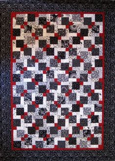 a black and white quilt with red accents