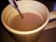 a spoon sticking out of a cup filled with liquid