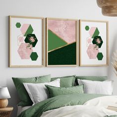 two green and pink art prints hanging above a bed