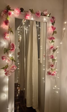 a mirror that has some lights on it and flowers in the reflection, along with other decorations