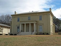 an old house with columns and pillars on the front