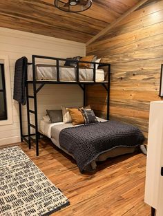 a bedroom with bunk beds and wooden walls