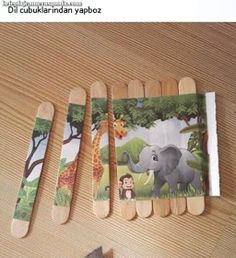 four toothpicks with pictures of animals and giraffes on them sitting on a table