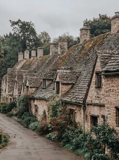 an old stone building with ivy growing on it's roof and walkway leading up to the buildings