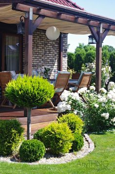 an outdoor patio with wooden furniture and flowers