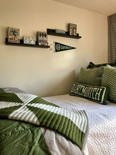 a bed with green and white pillows on top of it