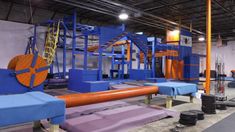 an indoor gym with equipment for people to play on and use as exercise mats in the floor