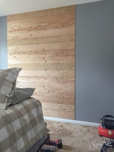 a bed room with a neatly made bed and a wooden wall