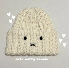 a white knitted hat with black eyes and ears