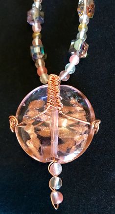 "Awesome Large Glass Pink and Copper Focal Bead Wire Wrapped in Copper with Tourmaline and Pink Glass AB Beads (Aurora Borealis) and Earrings to Match.  The focal bead is bound in copper wire.  Earrings to match made of bent copper wire and beads from the necklace in a creative drop, 3 1/4\" long, very lightweight.  The extra large handmade silver ear wires are wrapped in copper. Copper S-Clasp.  * Large Light Pink/Purple Glass Focal bead with Copper inside * Copper Wire Wrapping * Earrings to M Handmade Iridescent Jewelry With Round Beads, Iridescent Beaded Jewelry As A Gift, Handmade Iridescent Round Bead Jewelry, Iridescent Beaded Jewelry For Gift, Iridescent Beaded Round Bead Jewelry, Iridescent Round Beaded Jewelry, Bohemian Iridescent Round Bead Jewelry, Multicolor Wire Wrapped Crystal Necklaces With Round Beads, Handmade Iridescent Beaded Necklaces With Round Beads