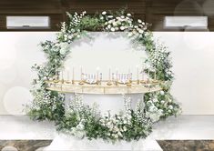 a table with flowers and candles on it in front of a wall that has lights