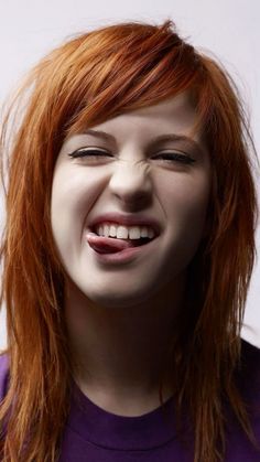 a close up of a person with red hair and white teeth smiling at the camera