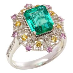 This ring designed by David Jerome is from his private collection and features one Emerald cut Emerald sourced in the chivor mine in Columbia totalling 3.03cts. Set with a mix of round brilliant cut Diamonds, pink and yellow Sapphires totalling 0.78cts combined. Mounted in platinum. Ring size UK N, EU size 54, USA size 6 1/2. David prides himself in only sourcing the finest and most exclusive gemstones whose natural beauty and colour enhance the settings he creates for each piece. These exclusive designs offer buyers a unique opportunity to own the kind of jewellery usually reserved for the finest and most exclusive brands in the world. A real legacy for the future. Luxury Green Sapphire Ring Gia Certified, Green Gia Certified Luxury Sapphire Ring, Green Gia Certified Sapphire Ring, Formal Multicolor Brilliant Cut Rings, Fine Jewelry Pink Sapphire Multi-stone Diamond Ring, Fine Jewelry Pink Sapphire Diamond Ring With Multi-stones, Luxury Green Sapphire Ring With Accent Stones, Elegant Multicolor Brilliant Cut Rings, Luxury Multi-stone Emerald Platinum Ring