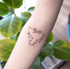 a woman's arm with a small tattoo design on the left side of her arm