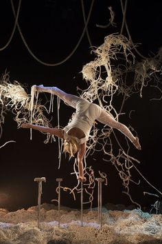 a person doing tricks on a pole in the middle of roped off area with ropes