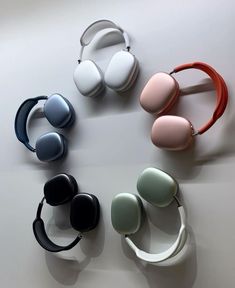 four different colored headphones sitting on top of a white table next to each other