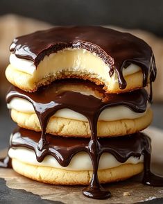 a stack of cookies with chocolate drizzled on top and white frosting