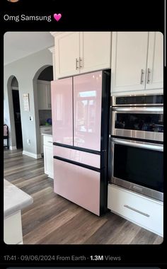 a pink refrigerator freezer sitting inside of a kitchen next to a stove top oven