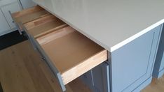 an open drawer in the middle of a kitchen counter