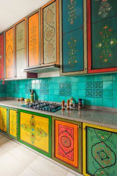 colorful kitchen cabinets painted in different colors and designs, with an island countertop on the side