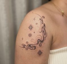 a woman with a tattoo on her arm and shoulder is looking at the stars in the sky