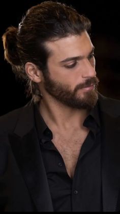 a man with long hair and beard wearing a suit