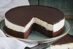 a chocolate and white cheesecake on a plate with one slice missing from the cake